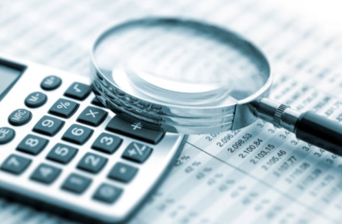 Reviewing expense report with a calculator 